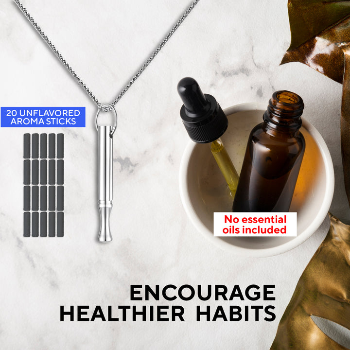 Essential oil inhaler necklace set with 20 unflavored aroma sticks shown on the left, a silver inhaler pendant in the center, and an amber dropper bottle with a pipette resting in a small white dish on the right. Text highlights 'No essential oils included' and slogan 'Trade your bad habit for a healthy one' on a marble background.
